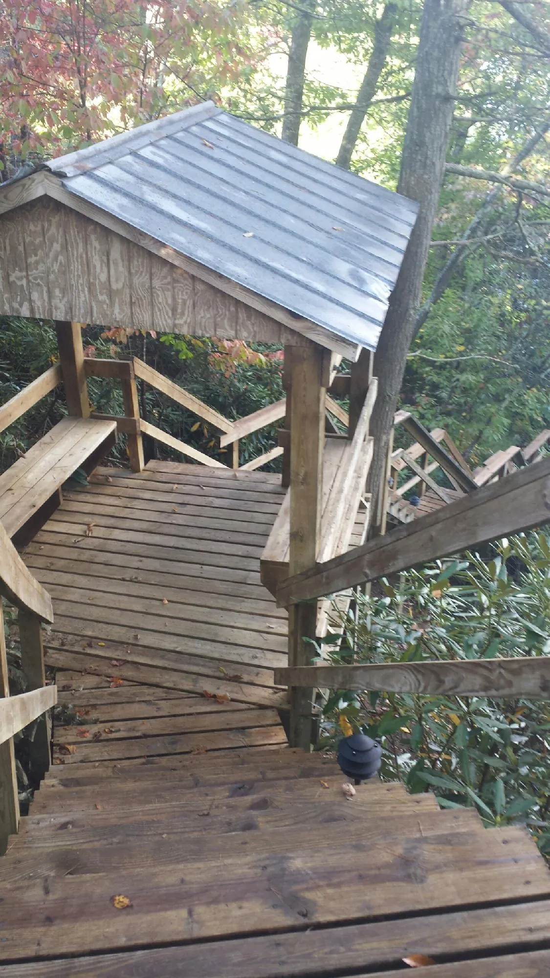 Metal roofed shelter over wooden steps on a wooded walkway — Skylight Repair & Installation work by our crew in Granite