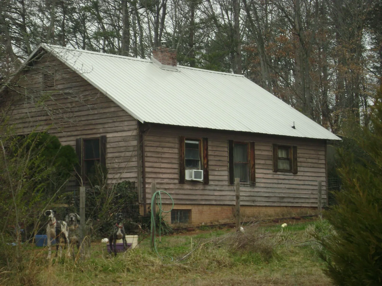 White metal roof on an old wood sided farmhouse, from a Metal Roof Installation job in Granite